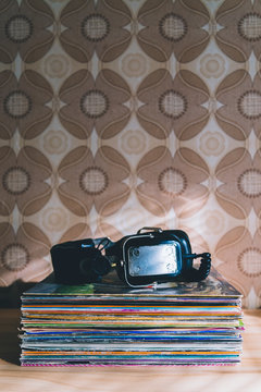 Big vintage headphones on stacked vinyl record albums