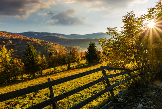 wooden fence in rural area at autumn sunrise. beautiful scenery in mountains
