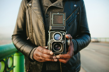 Close-up of man holding a vintage twin lens camera