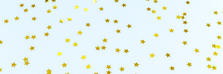 Golden star sprinkles on blue. Festive holiday background. Celebration concept