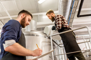 men working at craft brewery or beer plant