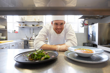 happy male chef cooking food at restaurant kitchen