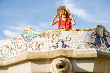 Obraz premium View on the beautiful terrace decorated with mosaic with happy woman tourist in Guell park in Barcelona