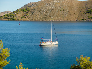 Sailing yacht in Croatia, anchoring in a bay, windy summer on the boat between rocky islands of the...