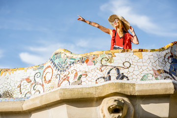 Obraz premium View on the beautiful terrace decorated with mosaic with happy woman tourist in Guell park in Barcelona