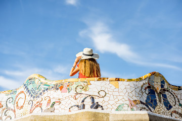 View on the beautiful terrace decorated with mosaic with happy woman tourist in Guell park in Barcelona