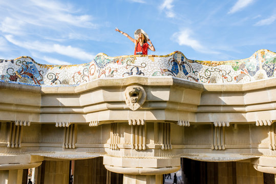 View on the beautiful terrace decorated with mosaic with happy woman tourist in Guell park in Barcelona
