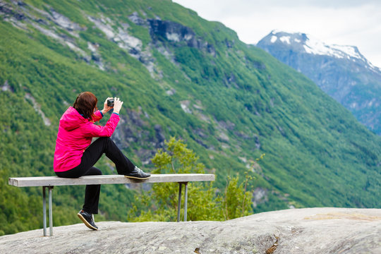 Tourist with camera looking at scenic view in mountains Norway