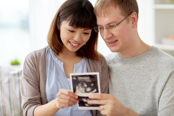 close up of happy couple with baby ultrasound