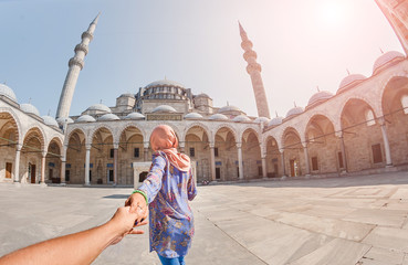 Follow me. A Muslim woman in a scarf leads her friend to the Turkish mosque Suleymaniye, travel and...