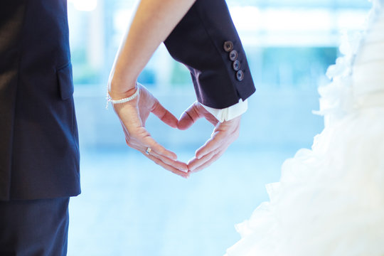 Couple forming heart with their hands