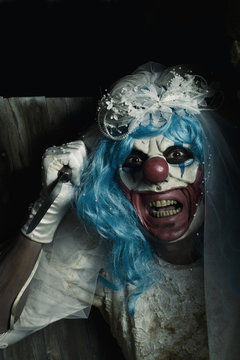 scary evil clown in a bride dress wielding a knife