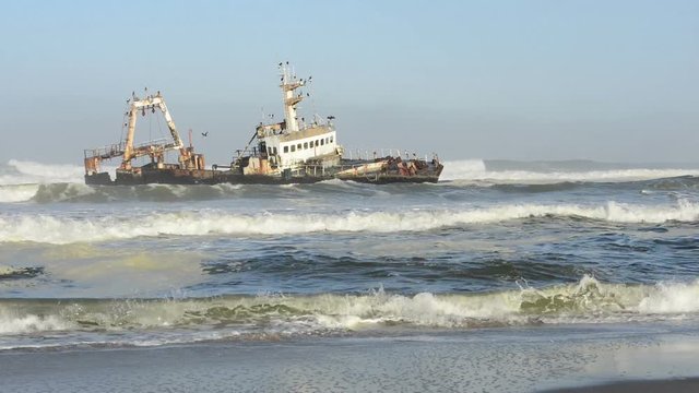 Sunken ship in the ocean breakers grounded at Namibia coastline