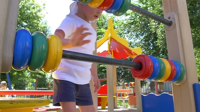 Boy child with a great pleasure finds the rings on the playground. Slow motion