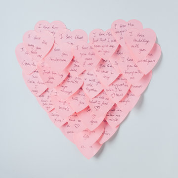 Pink heart made with adhesive notes against a white background