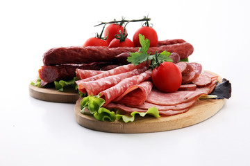 Food tray with delicious salami, pieces of sliced ham, sausage, tomatoes, salad and vegetable - Meat platter with selection - Cutting sausage and cured meat
