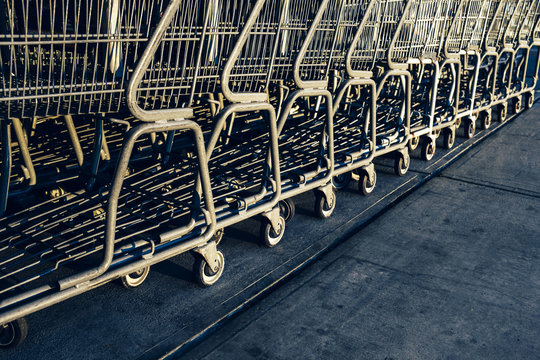 Metal grocery carts lined up on sidewalk outside supermarket
