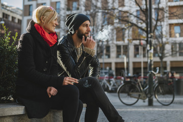 Young people smoking cigarette in the city