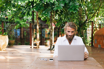 Young man working on computer in the garden