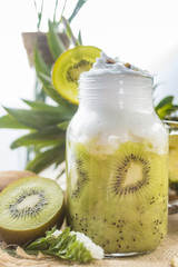 Healthy fresh kiwi smoothie in glass on a wooden background