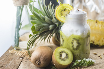 Healthy fresh kiwi smoothie in glass on a wooden background