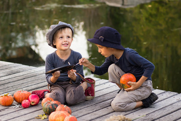 Fototapeta premium Laughing children paint small Halloween pumpkins