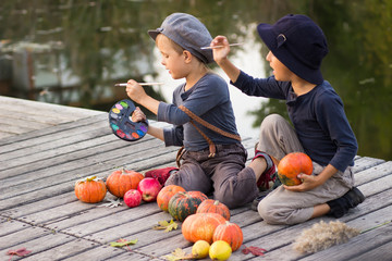 Fototapeta premium Nice children paint small Halloween pumpkins