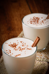 Eggnog houmemade with cinnamon and kakao for Christmas and winter holidays or wooden broun backgrounds