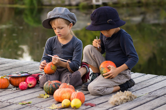 Active children paint small Halloween pumpkins