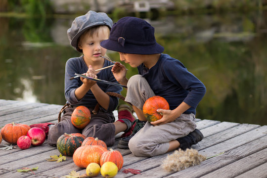 Active kids paint small Halloween pumpkins