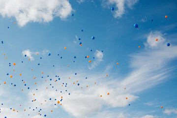 Blue and orange balloons in the sky