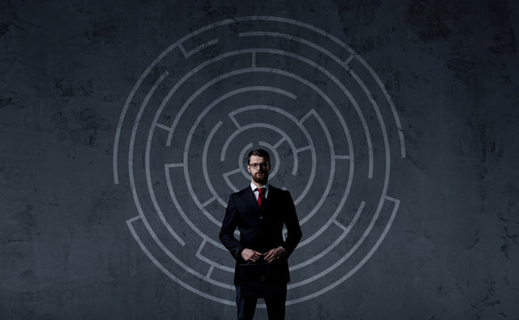 Businessman with briefcase standing over labyrinth background. Business, strategy, concept.