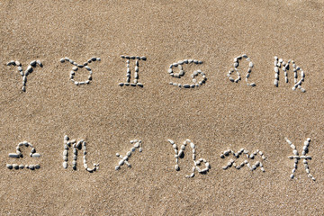 Signs of the zodiac horoscope laid out of sea stones on a sandy beach. Astrology for tourists and travelers.
