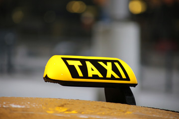 Taxi sign on taxi car with blurred city background, selective focus copy with space
