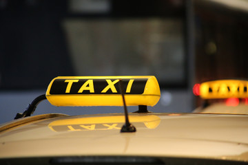 Taxi sign on taxi car with blurred city background, selective focus copy with space