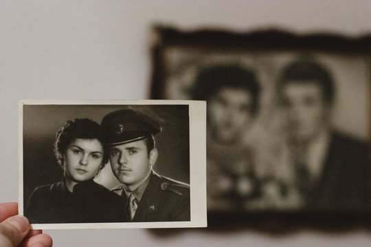 Senior Man Holding Old Photos and Reflecting Back on Memories