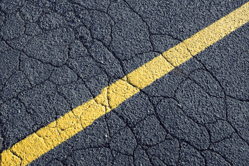 Painted yellow stripe on urban street, close up
