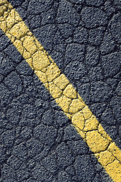 Painted yellow stripe on urban street, close up