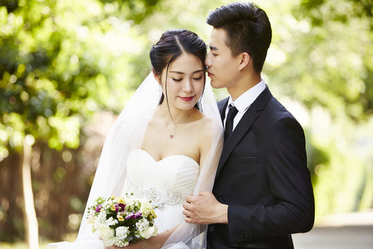 outdoor portrait of a newly-wed asian couple