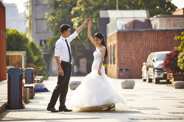 asian bride and groom dancing in parking lot