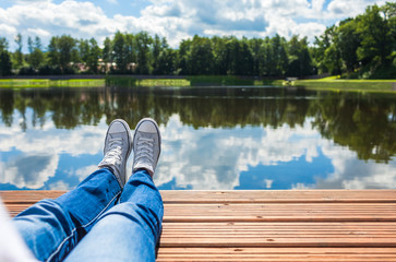 Obraz premium Woman relaxing her feet by the lake. 