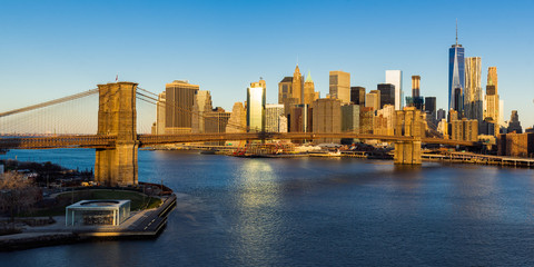 Sunrise on the Brooklyn Bridge, the East River and the skyscrapers of Lower Manhattan (panoramic). New York City