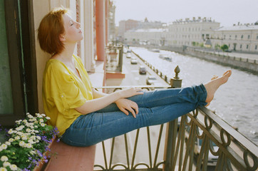 Young woman sitting on the balcony