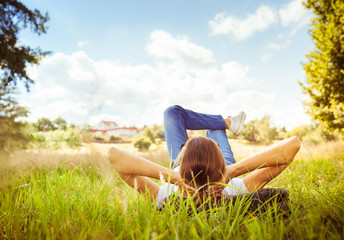 Chilling out in nature. Young girl lying on the grass on a beautiful sunny day. 