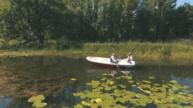top view on Couple is floating on a boat on the lake in wood