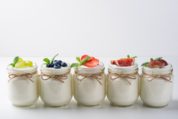 Fresh yogurt with berries in glass jars. Healthy food, dieting and breakfast concept. Copy space