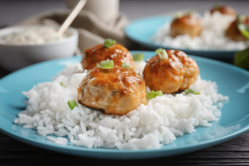 Plate with delicious meatballs and rice on table, closeup