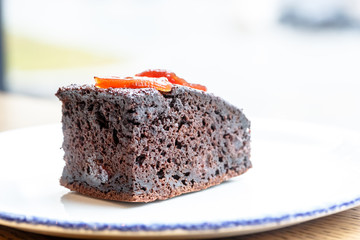 A piece of chocolate cake lying on the plate