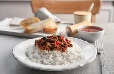 Chili con carne served with rice on table