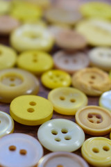 yellow sewing buttons on a wood table